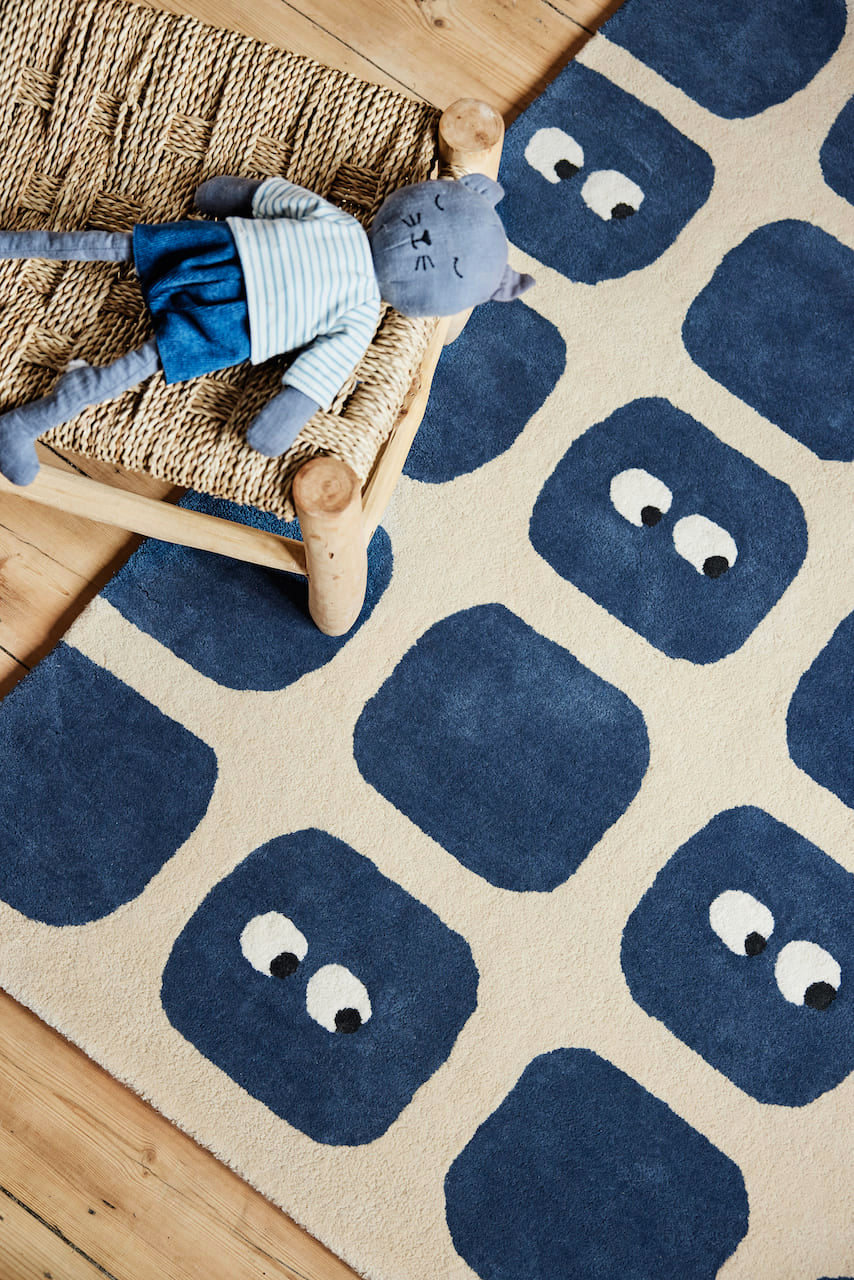 Tapis original pour chambre bébé garçon. En coton bio certifié GOTS. Sur fond beige, formes géométriques bleu dont certaines avec de petits yeux amusants. Une création originale de la marque française Bleuu-studio.