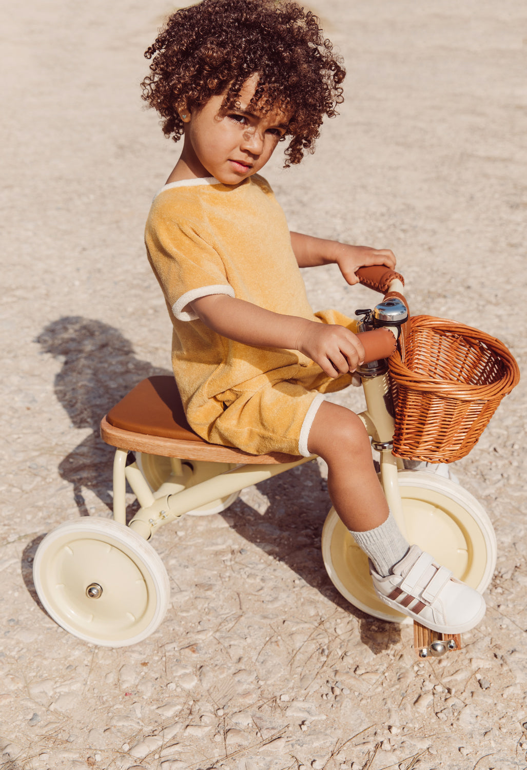 Enfant en balade avec le tricycle vintage Banwood et son panier en osier