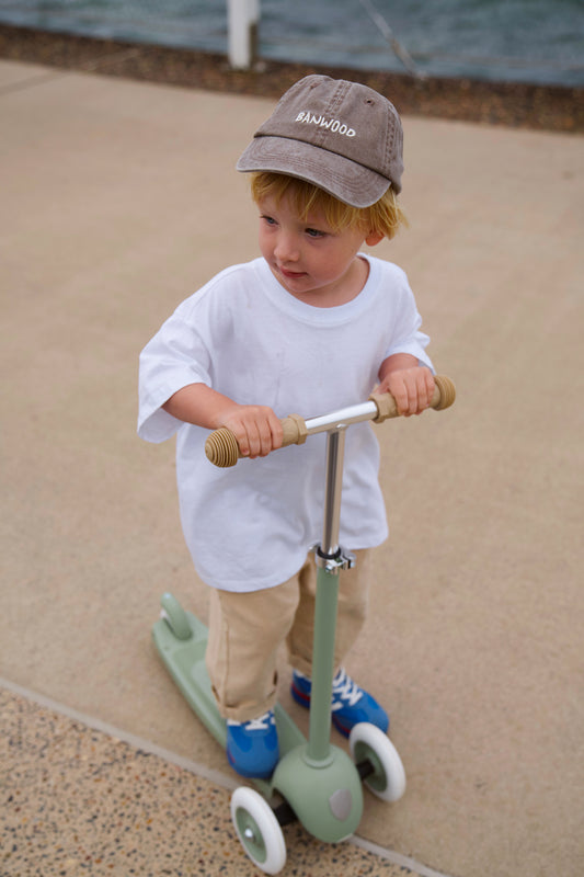 Trottinette verte Banwood utilisée en extérieur par un enfant