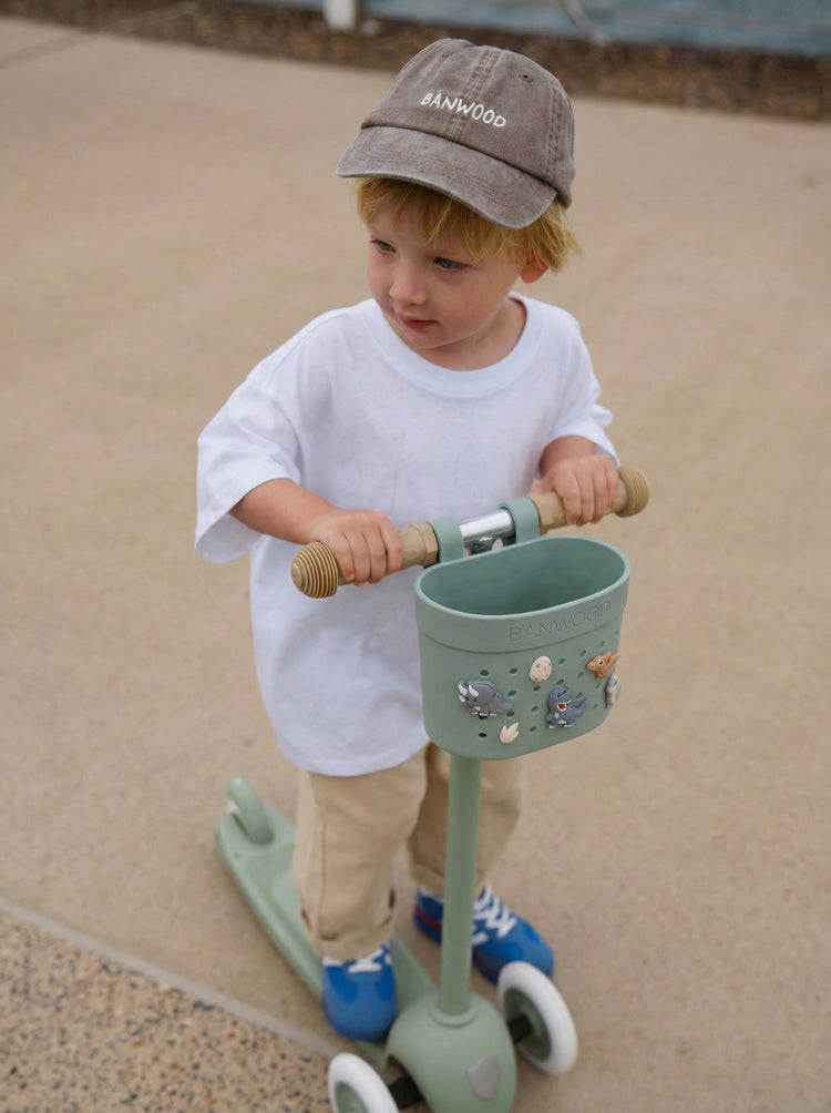 Trottinette verte Banwood pour enfant dès 3 ans avec panier décoré et pin's dinosaures