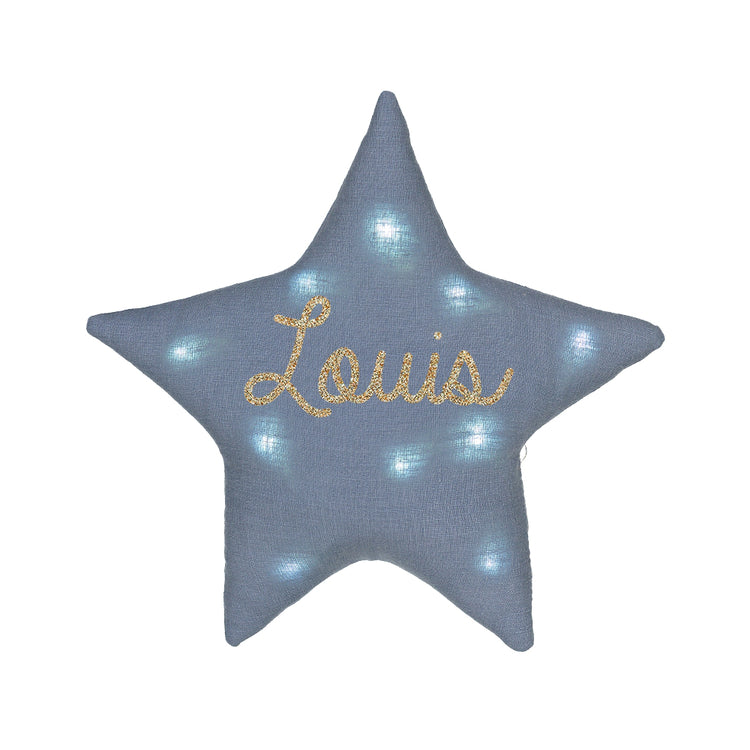 Veilleuse étoile en lin bleu grisé éclairée, personnalisée au prénom Louis en doré pailleté, sur fond blanc.