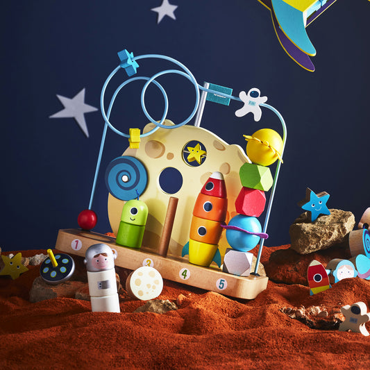 Jouet à compter en bois VILAC thème espace, scène lifestyle avec fusée et planètes.