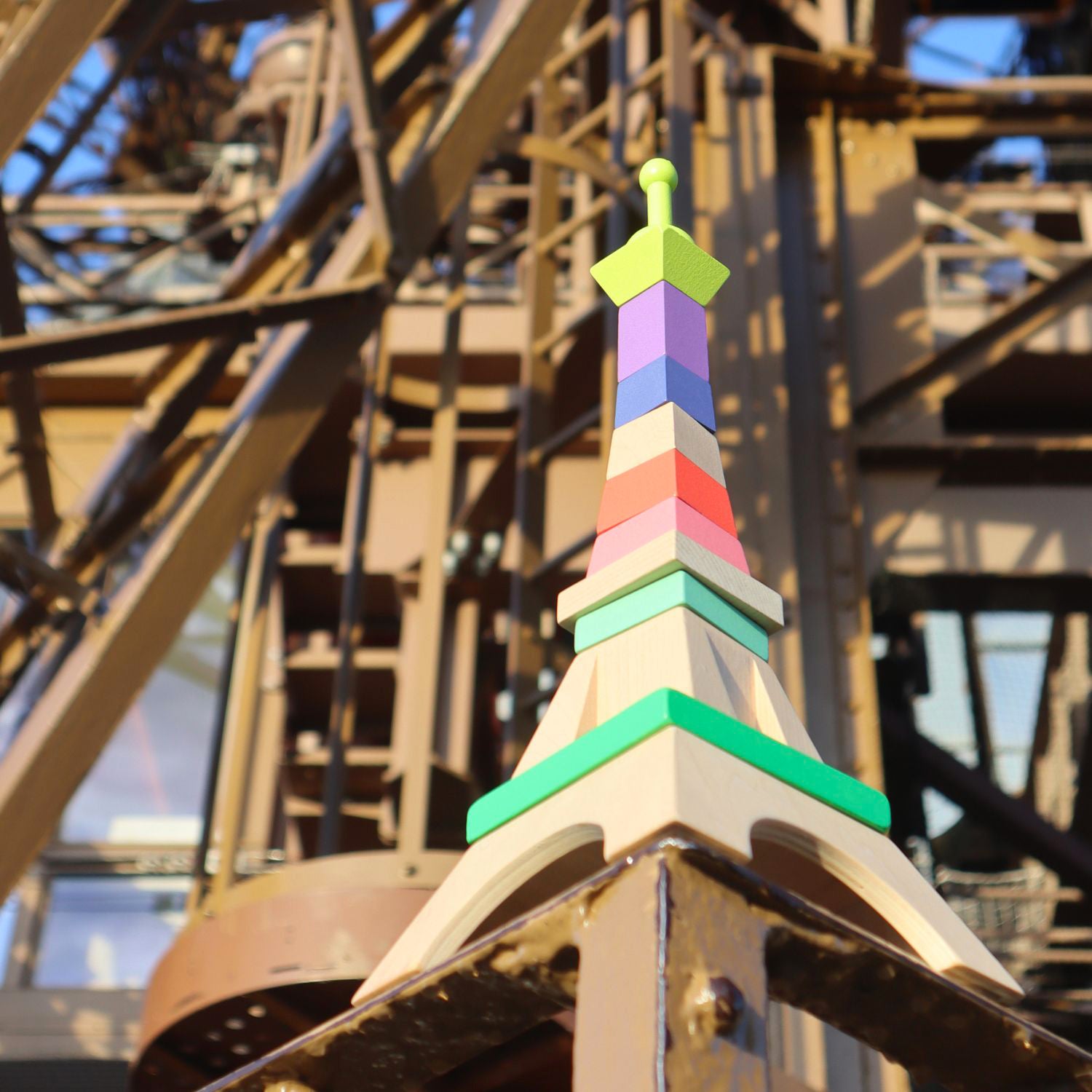 Tour Eiffel en bois multicolore VILAC posée sur balustrade, jouet Montessori.