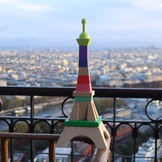 Tour Eiffel en bois VILAC surplombant Paris : jouet d’éveil à empiler dès 1 an.