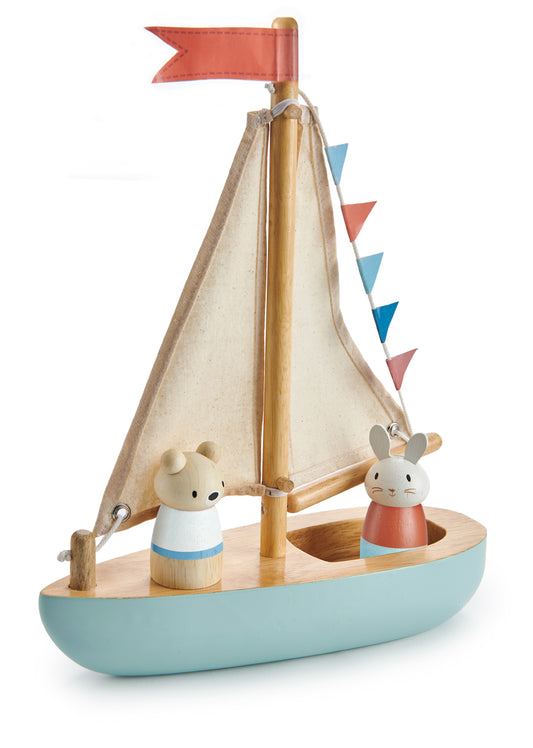 Bateau en bois massif : coque bleu ciel et pont en bois naturel clair, voile en tissu de couleur lin, banderoles à fanions rouge et bleu. A son bord, les deux personnages en bois Squeak et Bubble. Jouet en bois durable Tender Leaf.